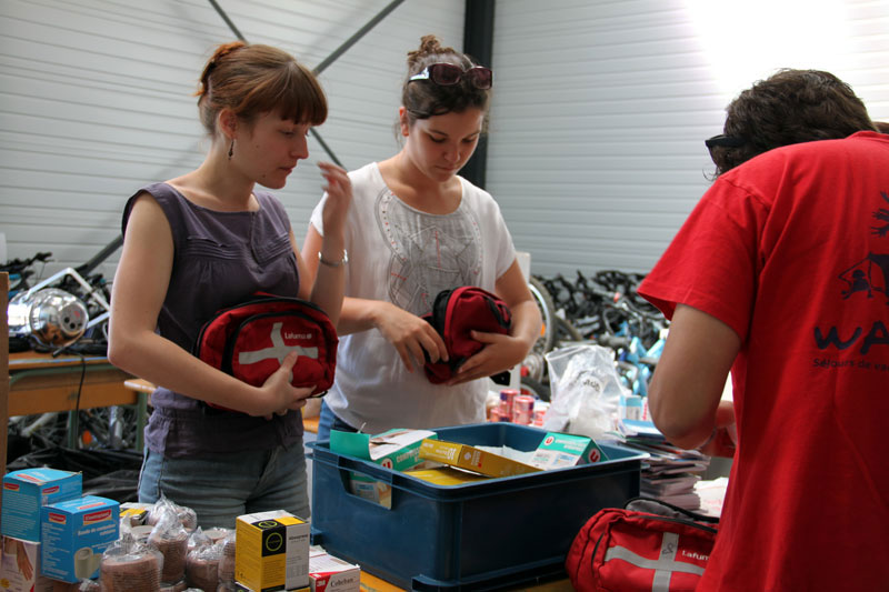 Maelenn, Camille et Johan s’affairent à préparer les malles qui équiperont les infirmeries de nos centres de vacances.