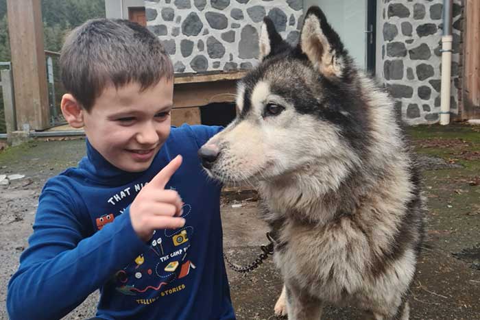 Photo souvenir d'un enfant avec un chien de la meute.