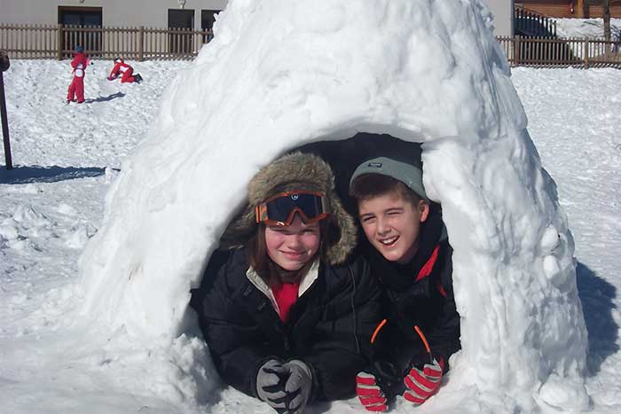 Moment souvenir de la construction d'un igloo au pied du centre de vacances.