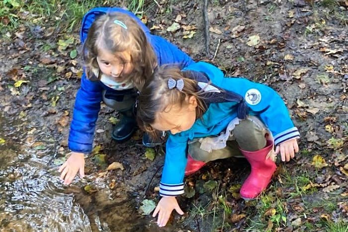 Des enfants jouent au bord d'un ruisseau